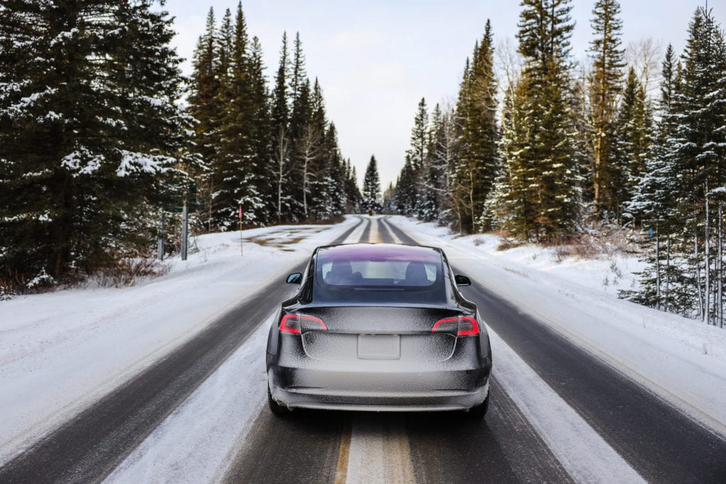 Car driving on snowy road in the woods