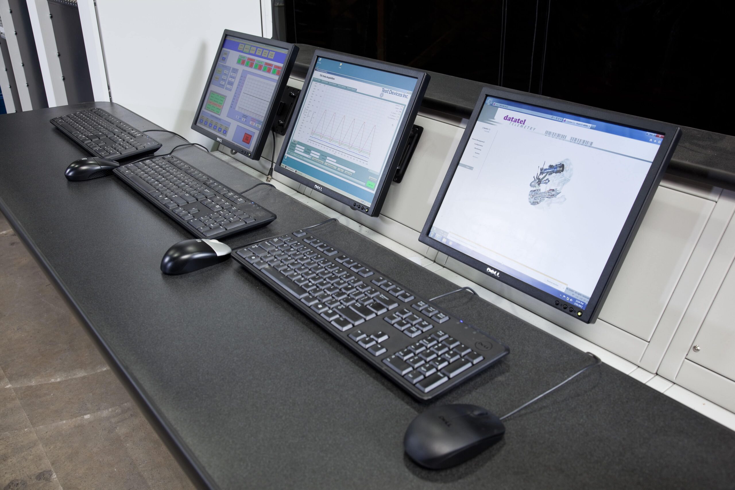 Three computer monitors for reviewing spin and balance testing results
