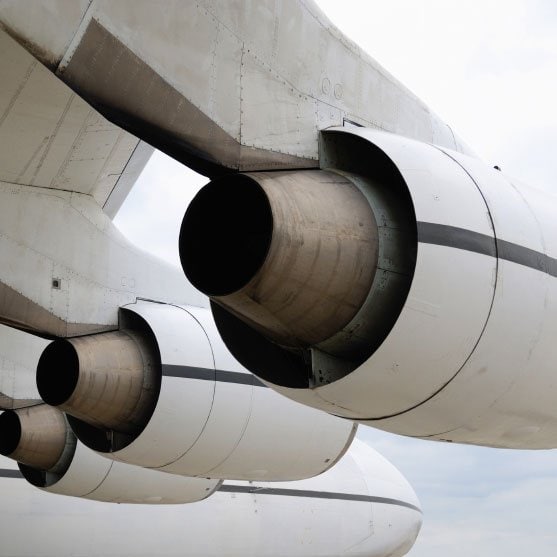 Turbines on white airplane with sky in background
